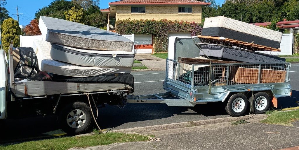 Waymaker ute and caged trailer fully loaded with mattresses and furniture for rubbish removal