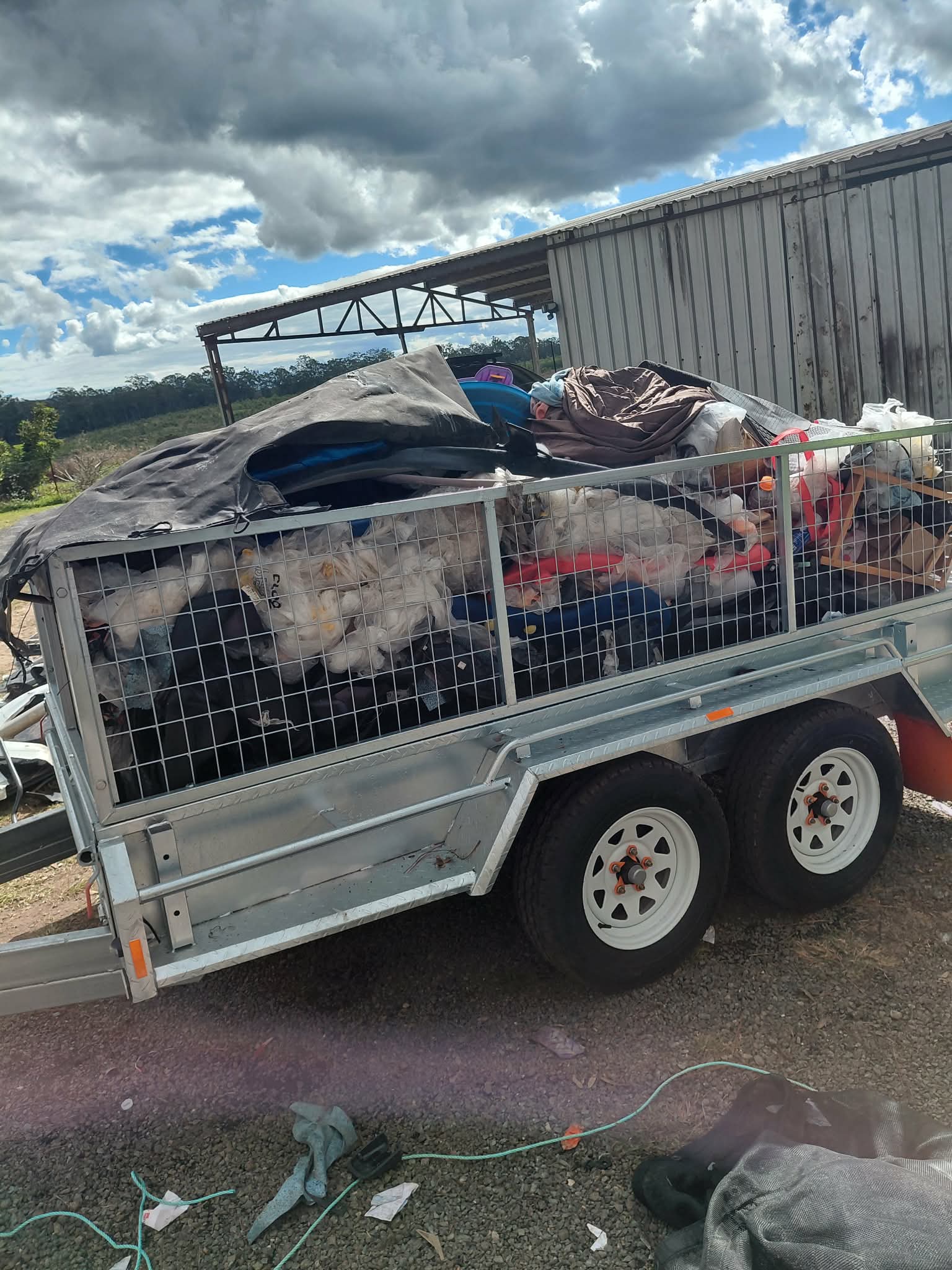Caged trailer loaded with household rubbish and waste for removal