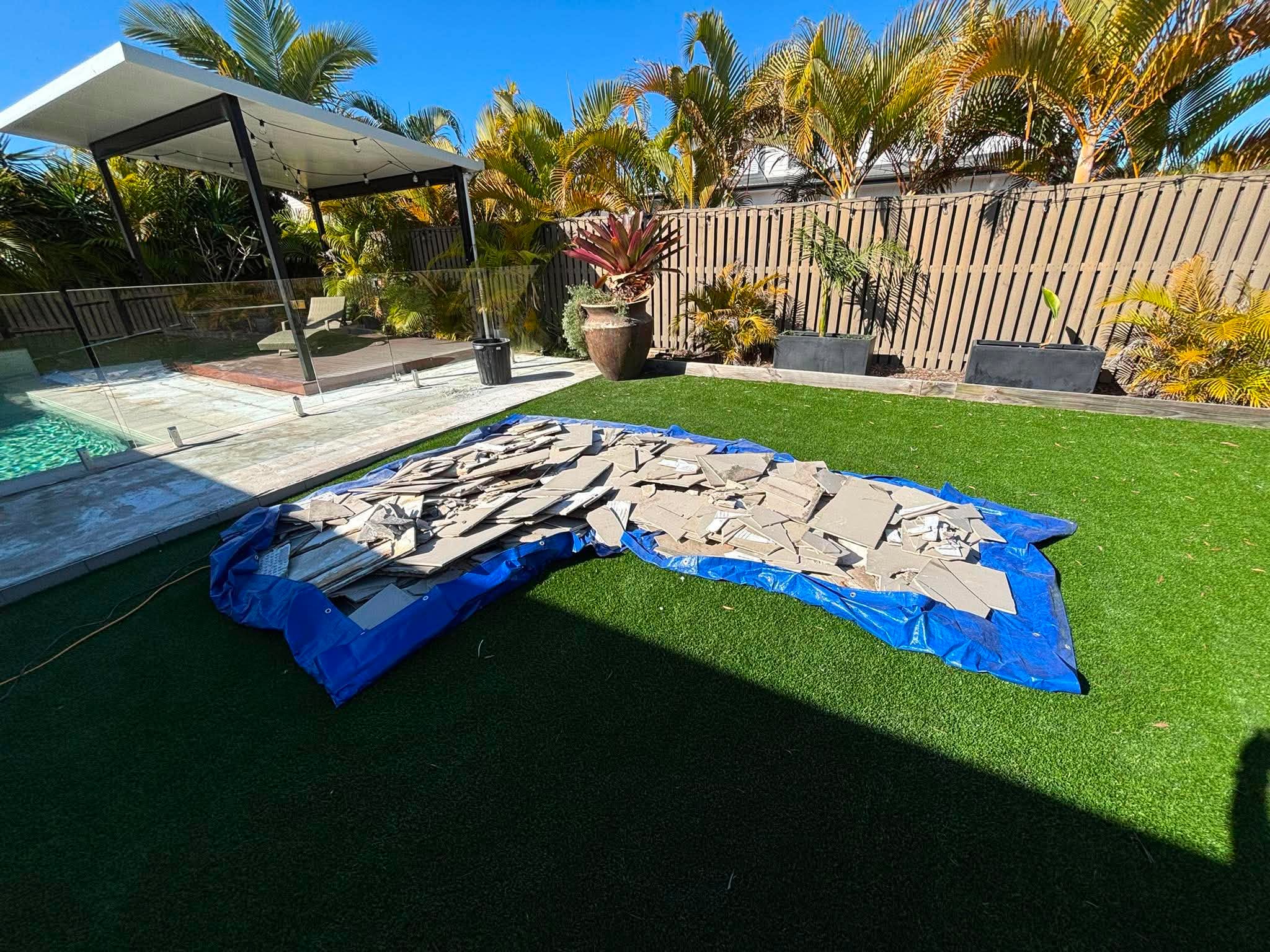 Renovation tile and debris piled on a tarp before rubbish removal