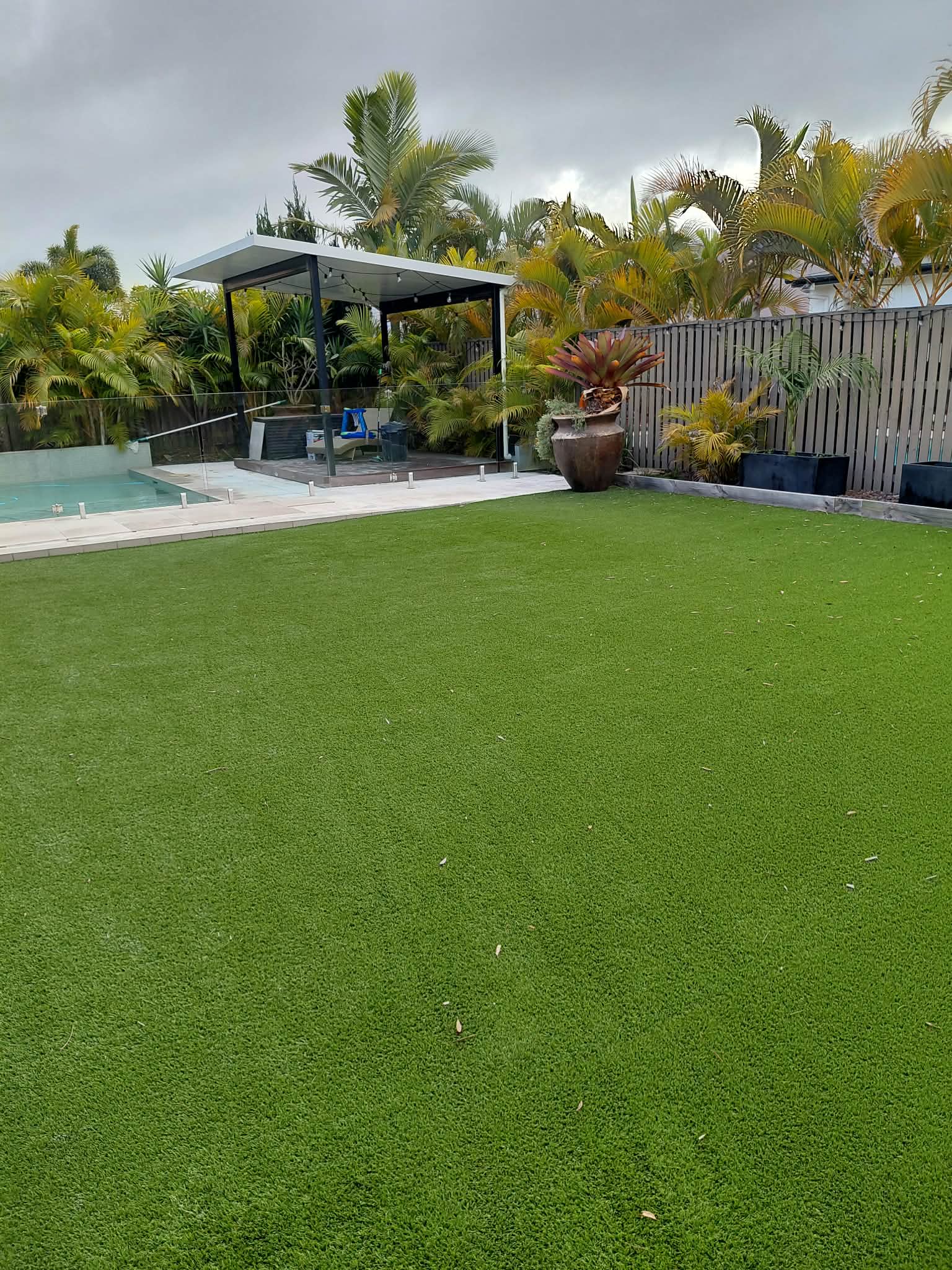 Cleared backyard after tile and rubbish removal beside a pool