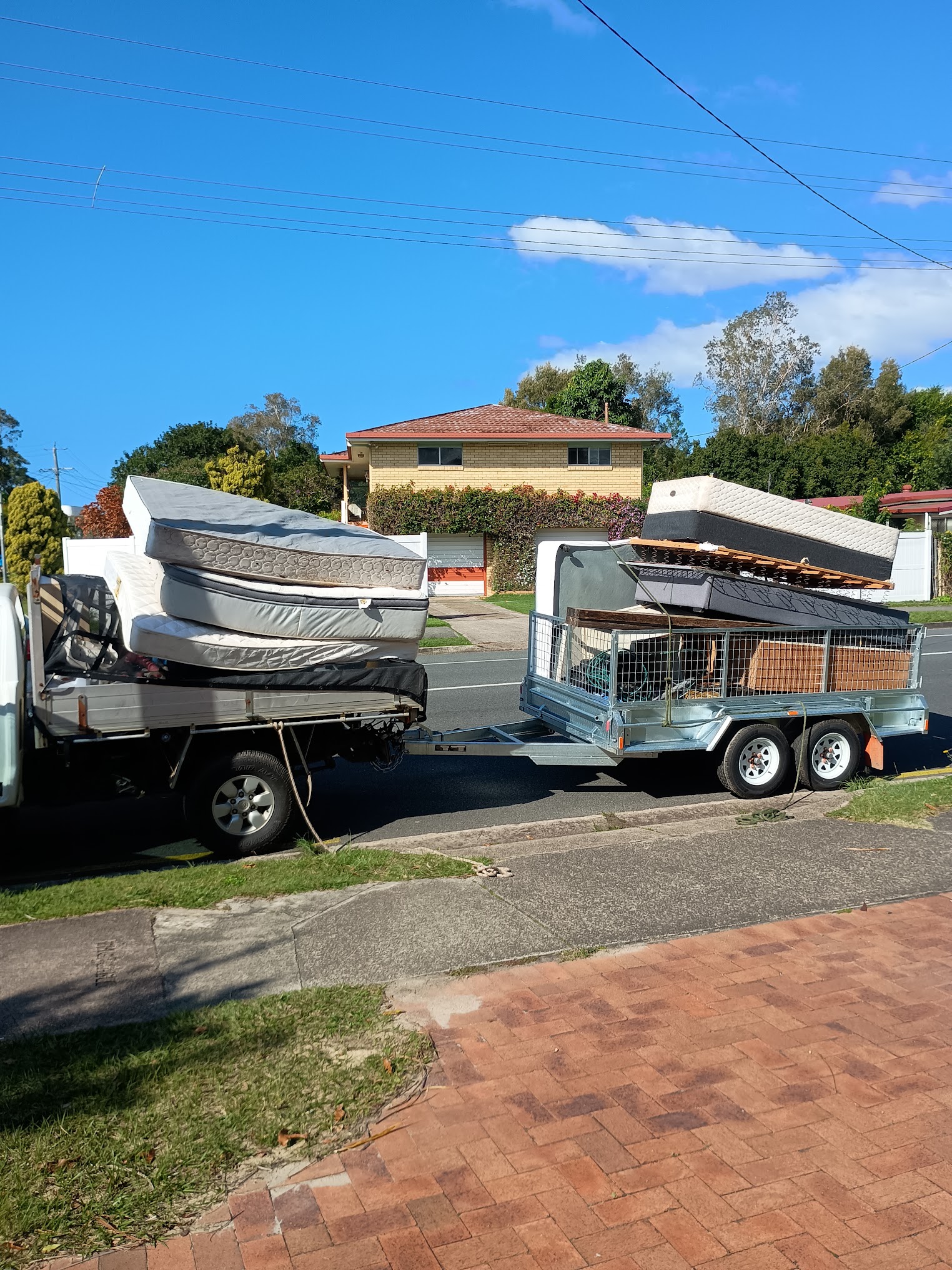 WayMaker ute and caged trailer loaded with mattresses for removal